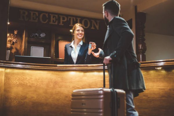 Man just arriving in hotel and receiving keys from his room after check-in